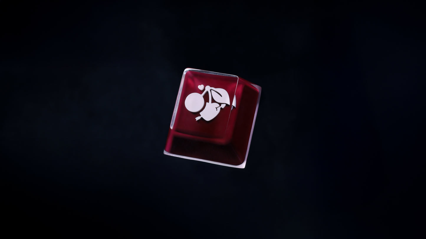 Square keycap accessory with white Cherry-style emblem in red-tinted case