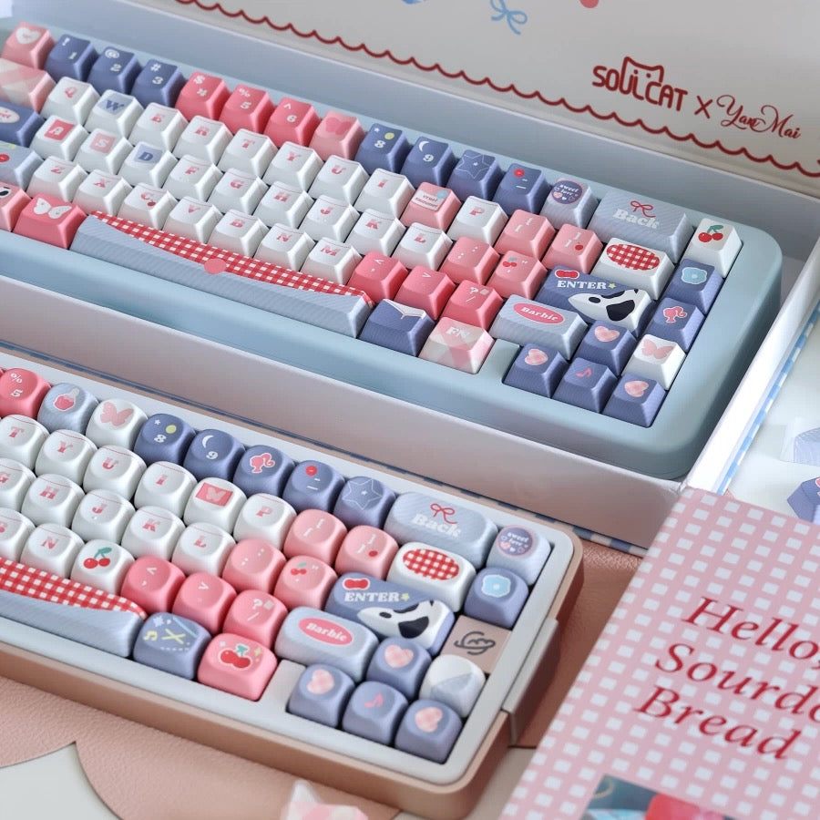 Cowgirl keycap set in light blue tray with pink and gray keys, checkered Enter key