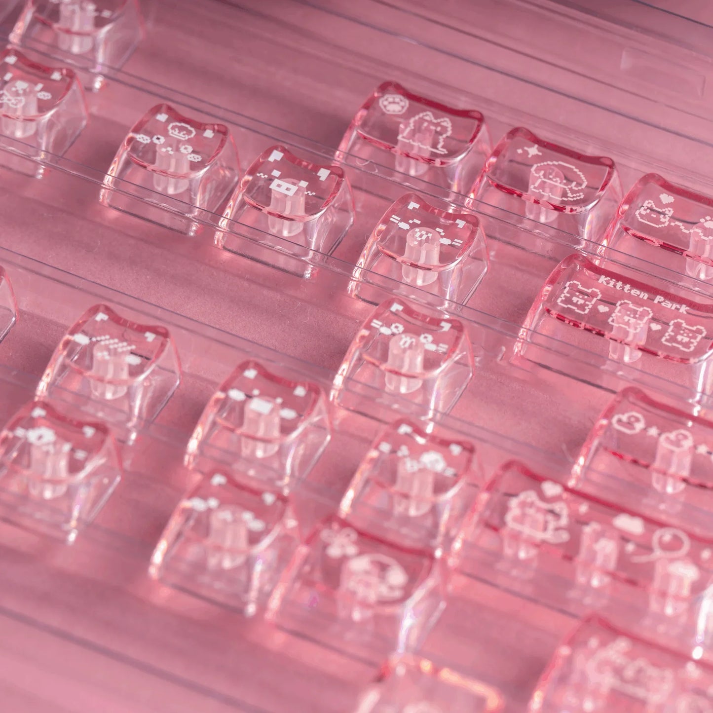 Keycaps in individual clear covers, pink-themed cat and pattern designs visible on top