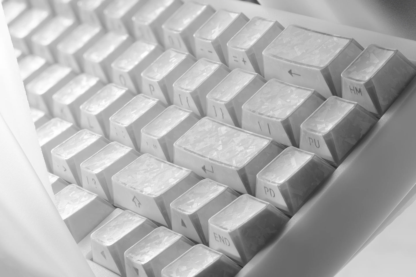 Corner close-up of white prism forged carbon keycaps with subtle etched legends