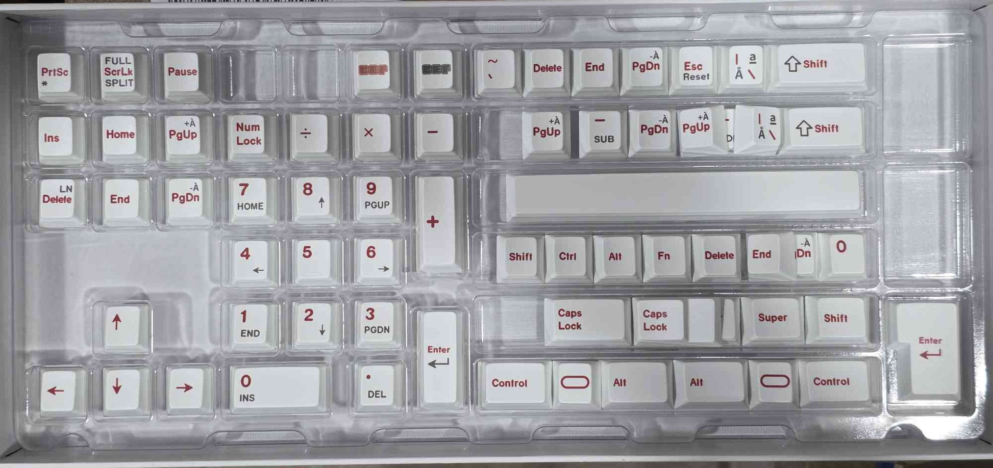 Keycap set with red legends on light-gray keys in a tray, showing navigation and control keys