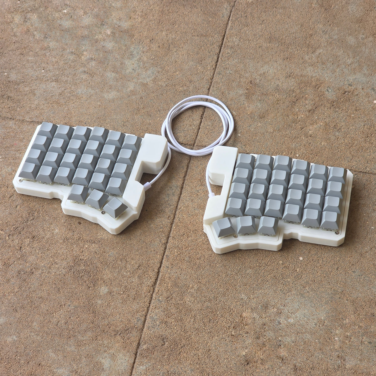 Split wired keyboard with light gray keycaps and white cable, two-piece layout