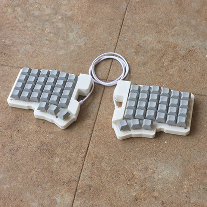 Split wired keyboard with light gray keycaps and white cable, two-piece layout