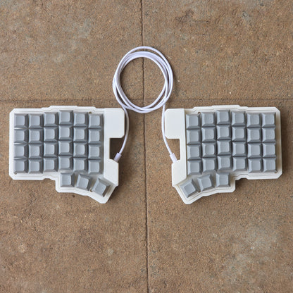 Split wired keyboard with light gray keycaps and white cable, two-piece layout