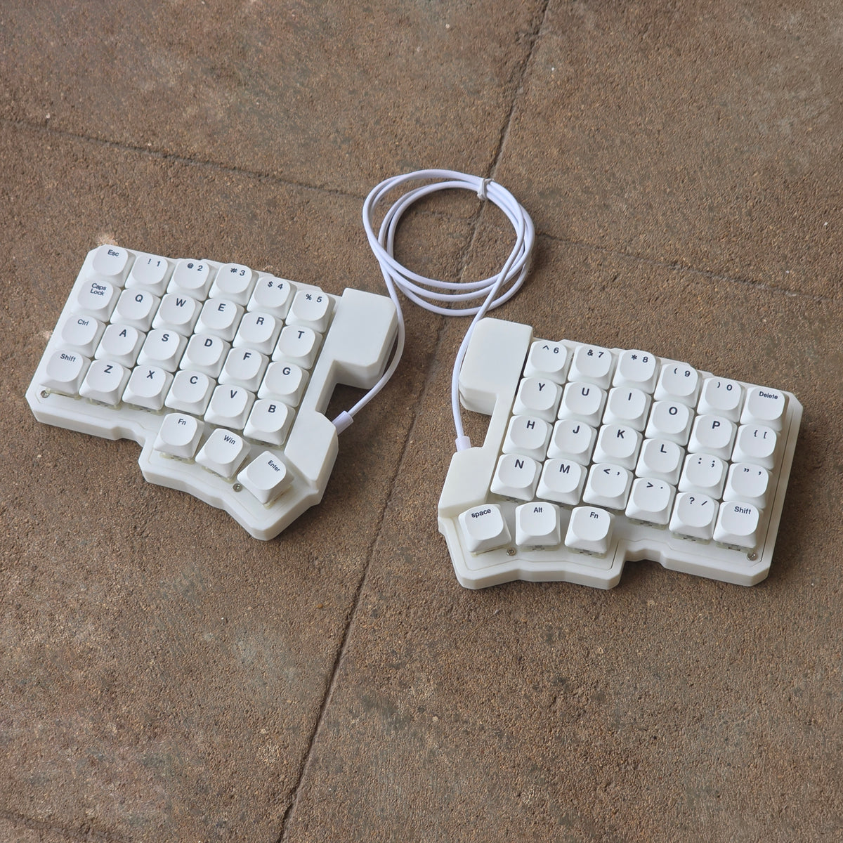 Split wired keyboard with white keycaps and white cable, two-piece layout