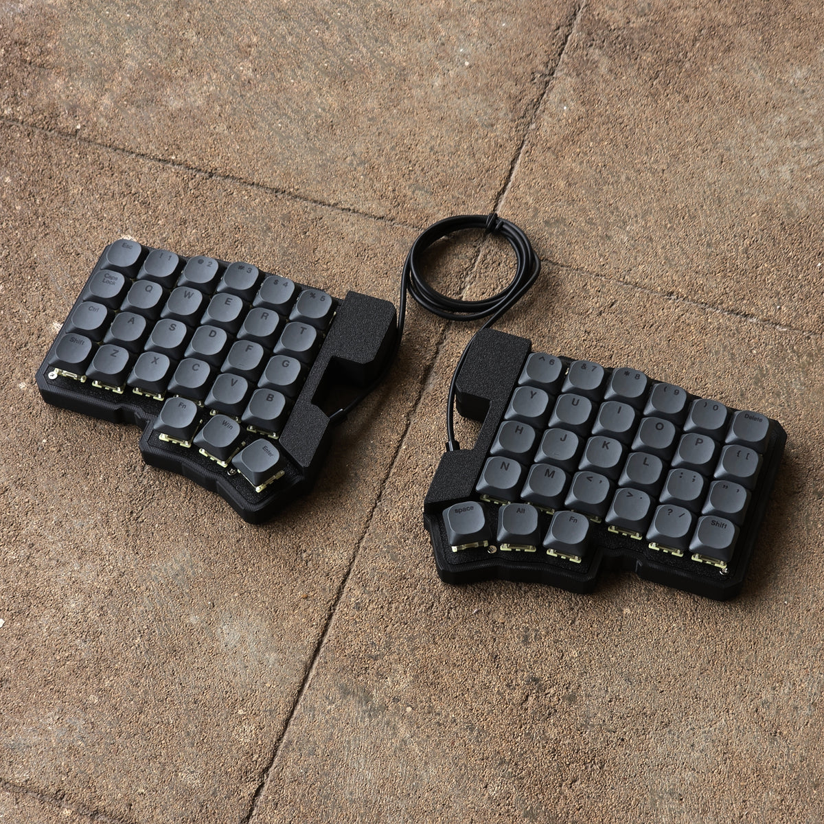 Split wired keyboard with dark gray keycaps and black cable, compact two-piece layout