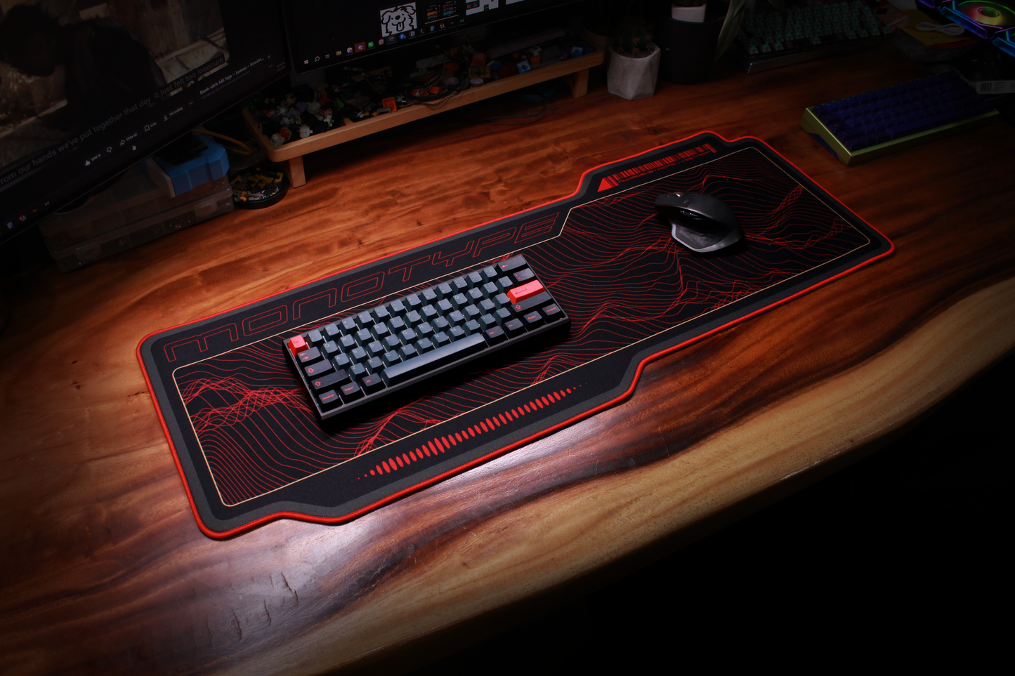 Crimson desk mat with red topographic line artwork and glowing border