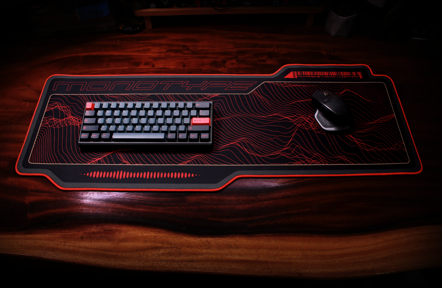 Crimson desk mat with red topographic line artwork and glowing border
