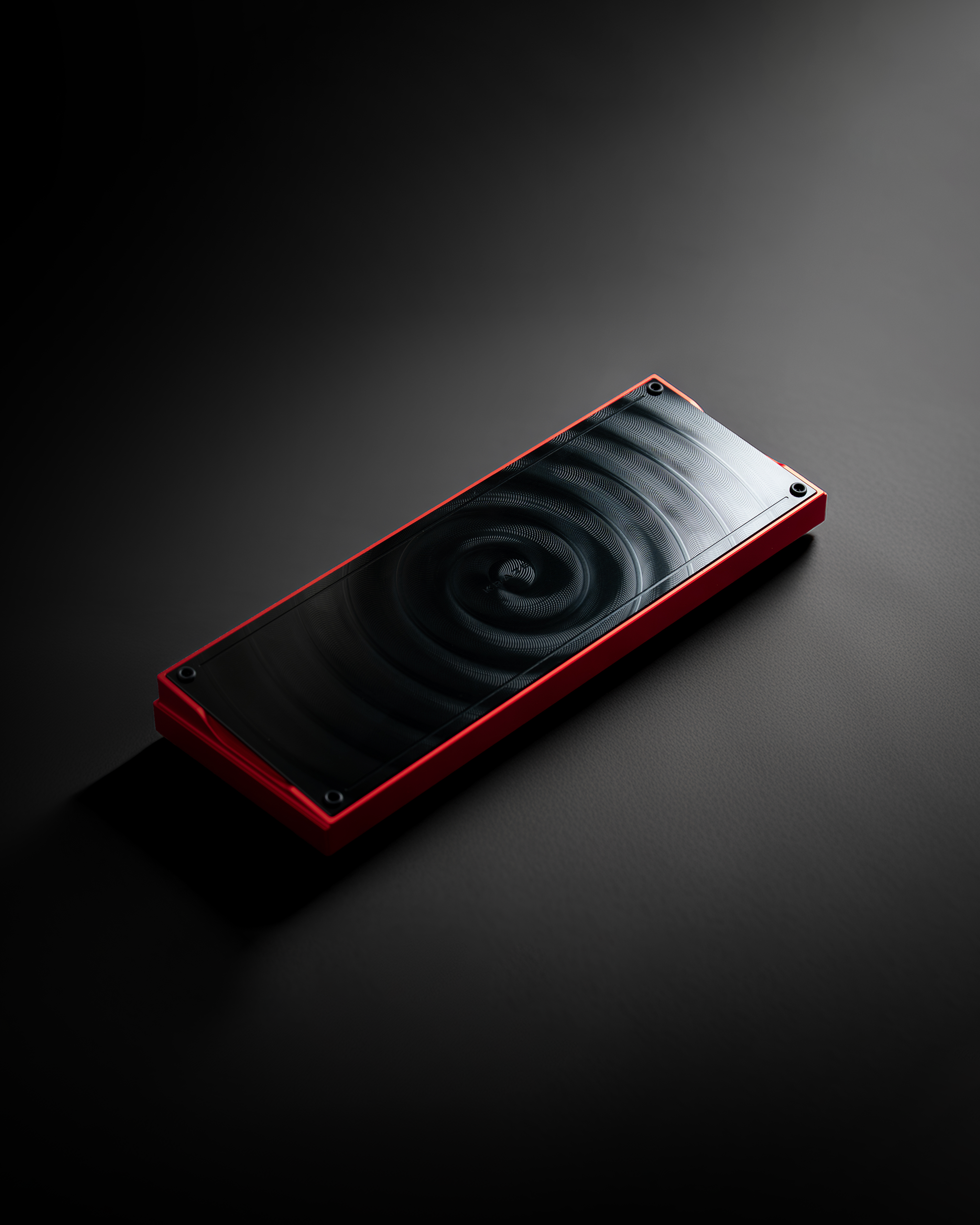 Red-framed keyboard component with dark fan grille surface