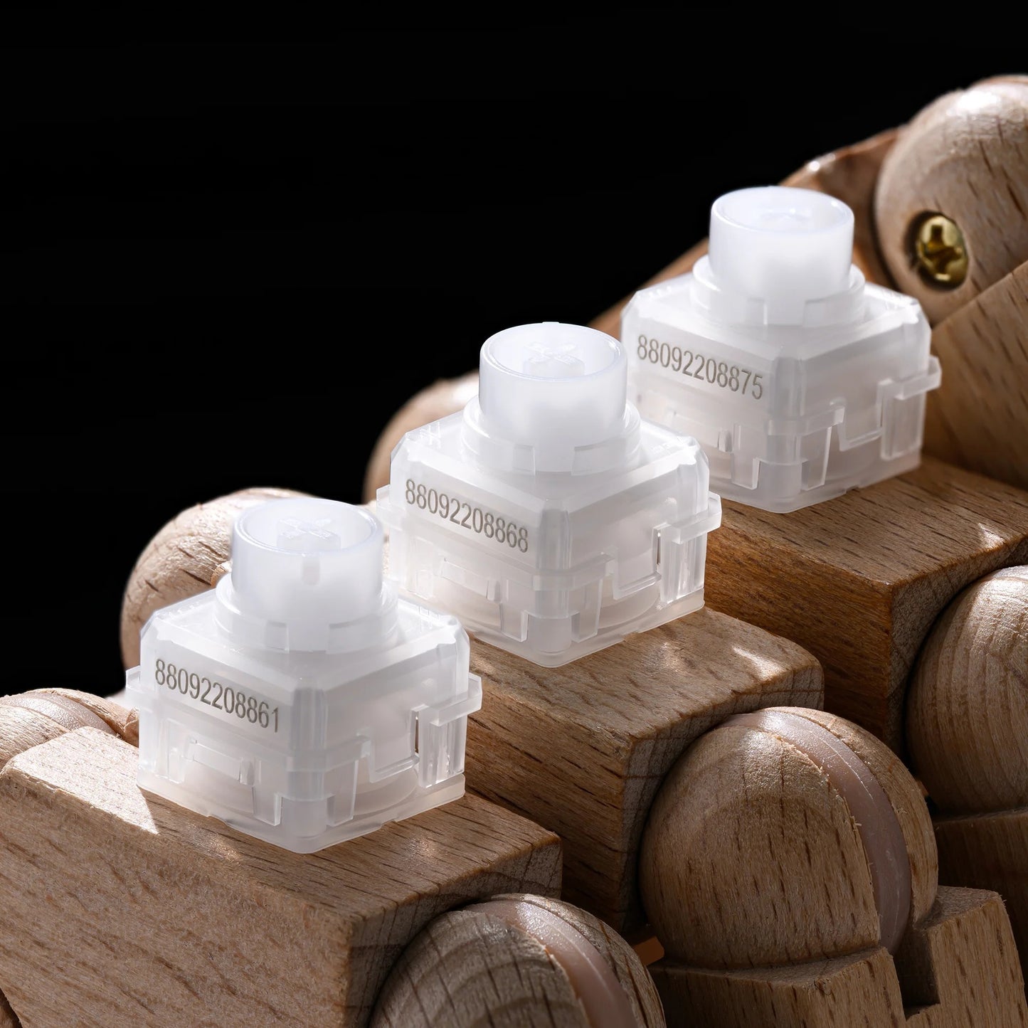 Set of transparent Whisper silent switches with white caps on wooden blocks