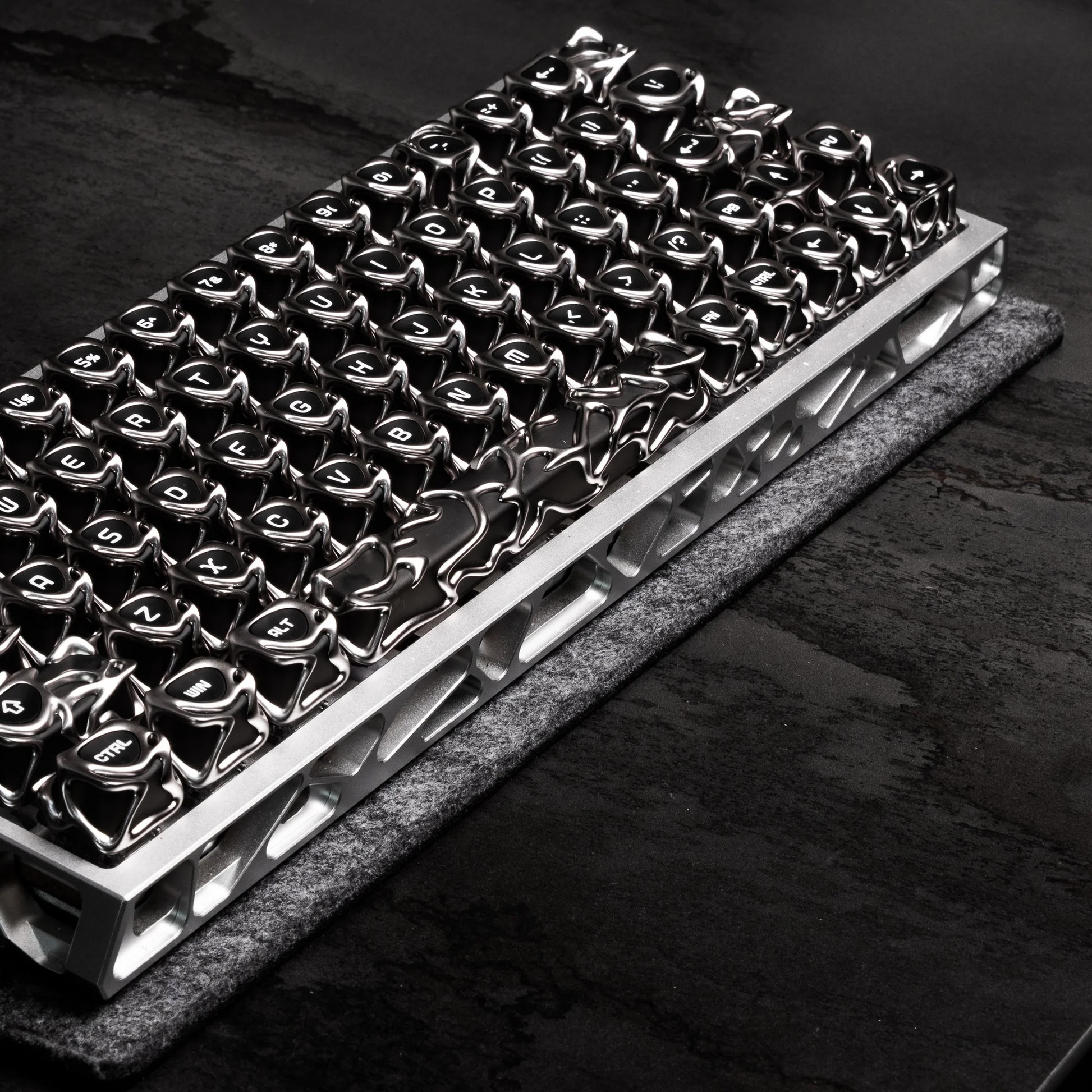 Keyboard tray with glossy black and silver keycaps on dark base