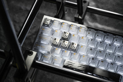 Keycap tray showing rows of alphabet-engraved keycaps with dark legends