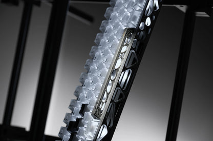 Side view of keycap tray showing stacked dark keycaps and metal frame