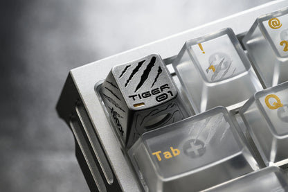 Keycap insert with tiger-themed engraving and Tab keycap in a metal tray