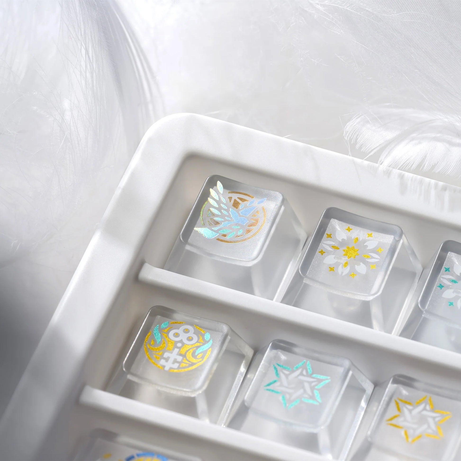 Clear organizer tray with gold and white stained-glass style keycaps and decorative icons