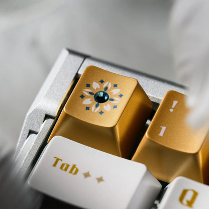 Keycaps tray showing the “Tab” key with gold and white stained-glass floral gem design
