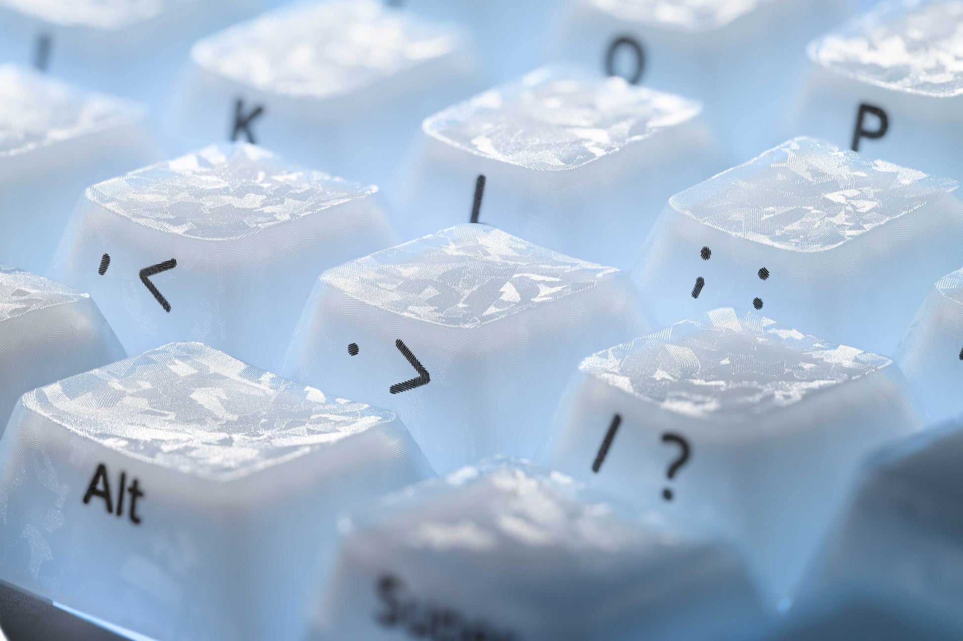 Set of white keycaps with symbols and letters on a light tray