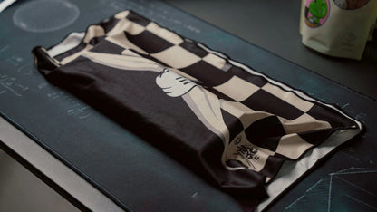 Folded keyboard cloth with black-and-white checkerboard design and cartoon hand motif