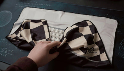 Keyboard cloth on a keyboard with black-and-white check pattern and hand graphic