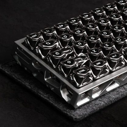 Metal keyboard tray filled with glossy black and silver keycaps