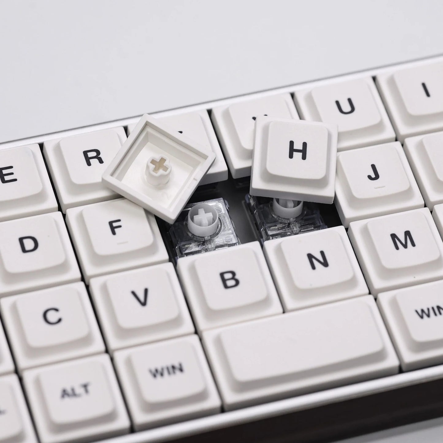 Low-profile keycaps close-up showing white keys with Win, Alt, and arrow legends