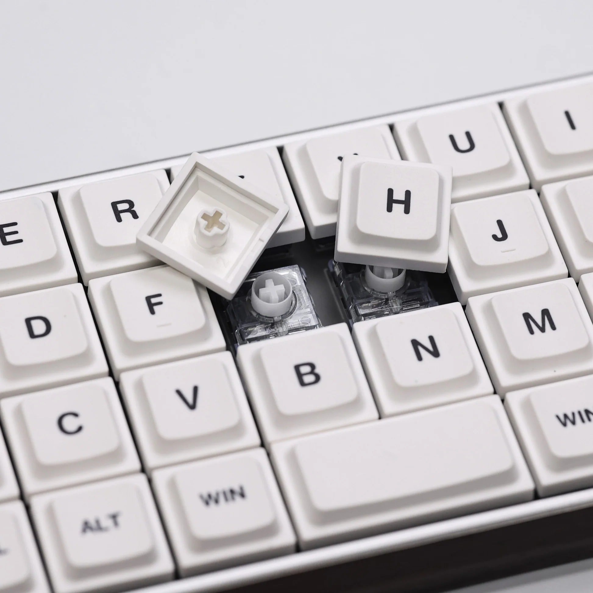 Low-profile keycaps close-up showing white keys with Win, Alt, and arrow legends